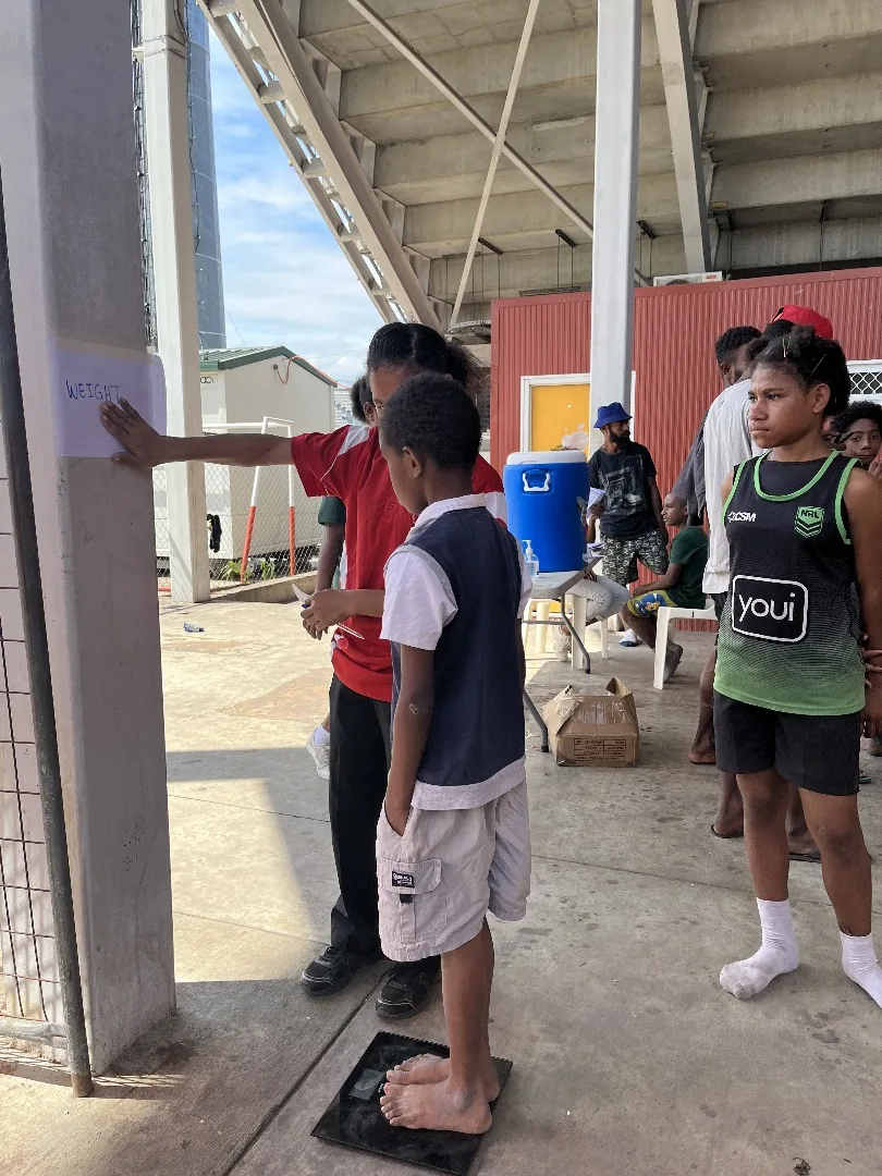 A health professional speaks with a person at a community screening