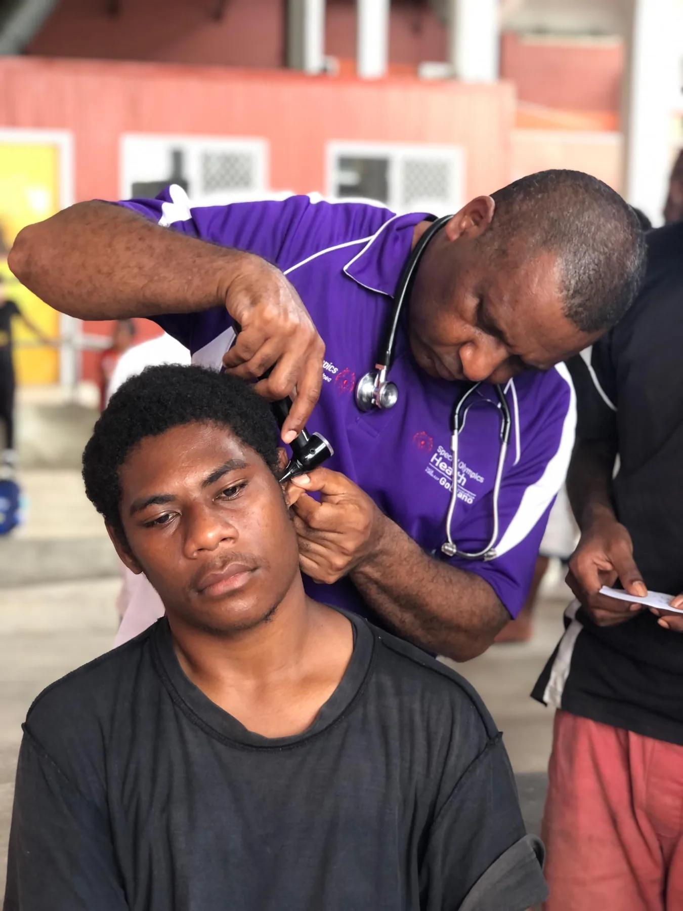 A health worker supports an athlete during a check-up